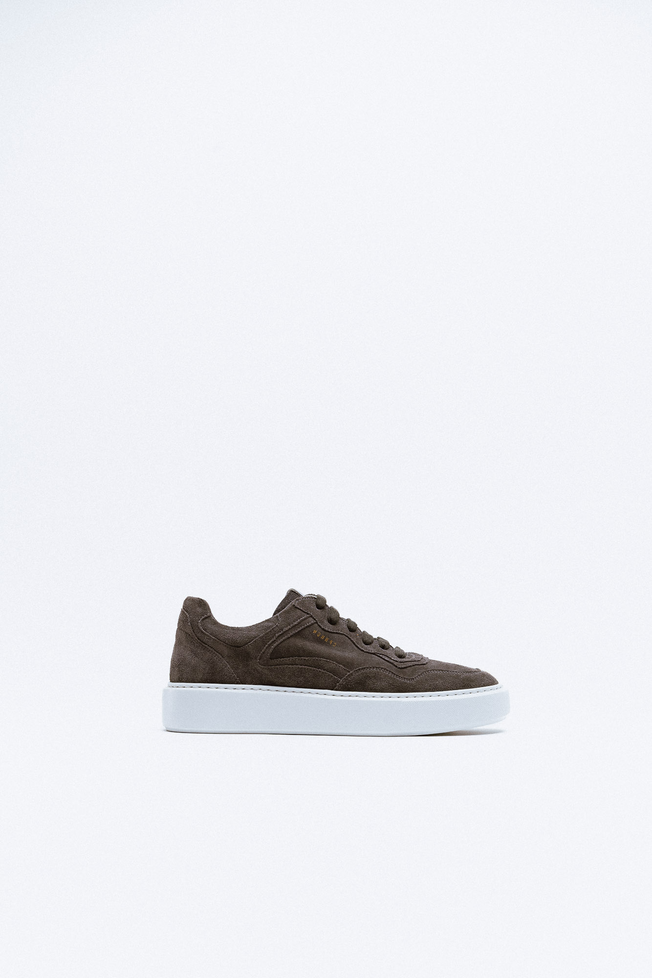 A dark brown suede sneaker with white platform sole.