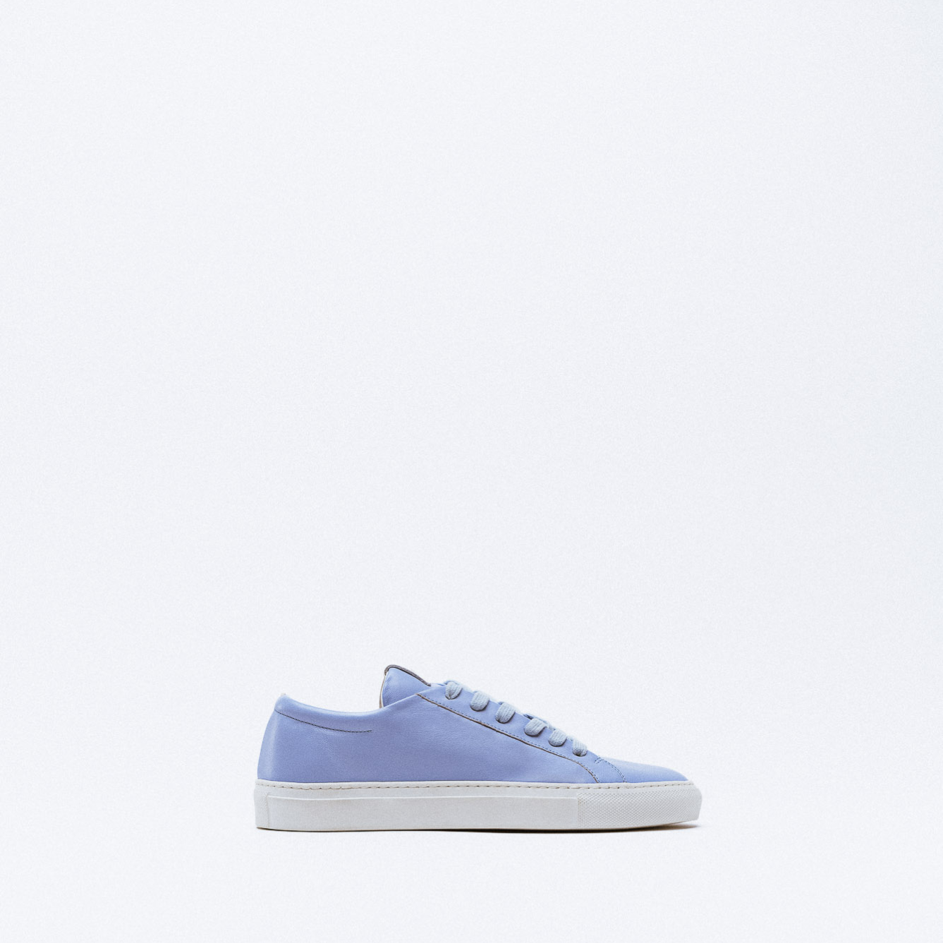 A powder blue leather sneaker with matching laces and white rubber sole.
