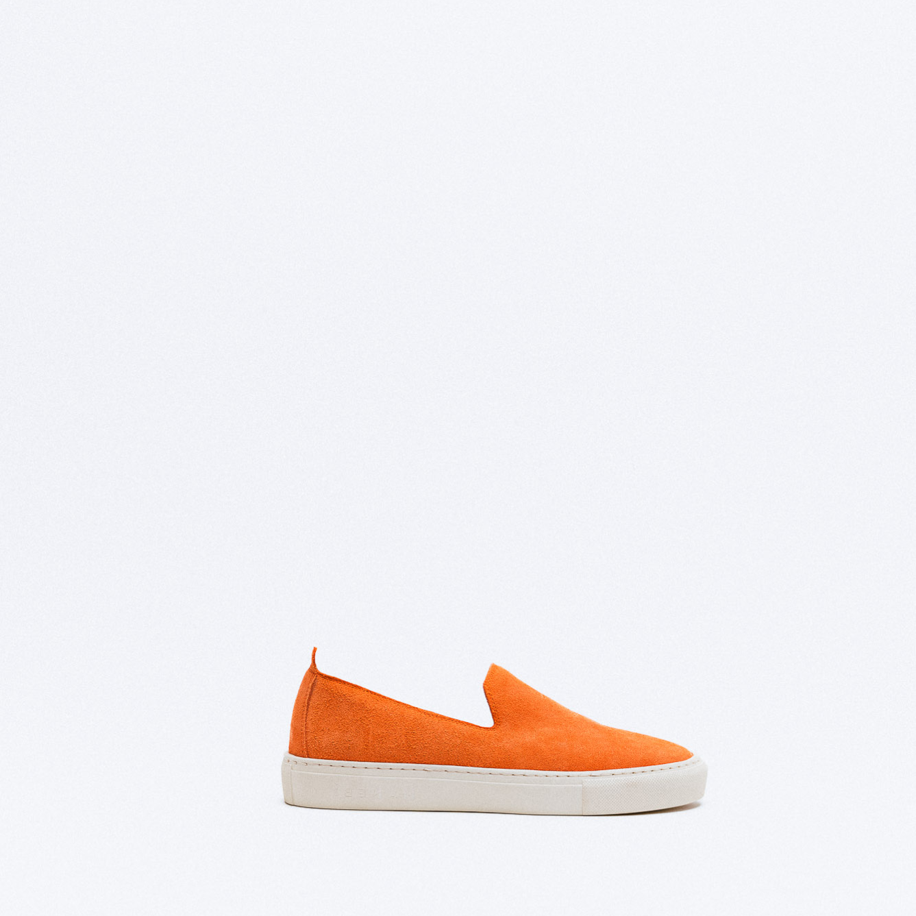 An orange suede slip-on sneaker with a white platform sole.