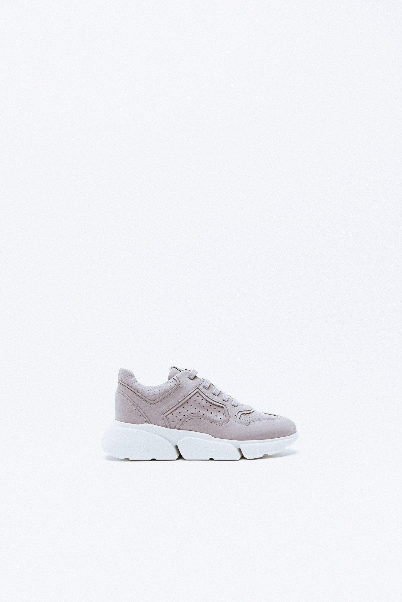 A taupe leather sneaker with perforated detailing and a chunky white segmented sole.
