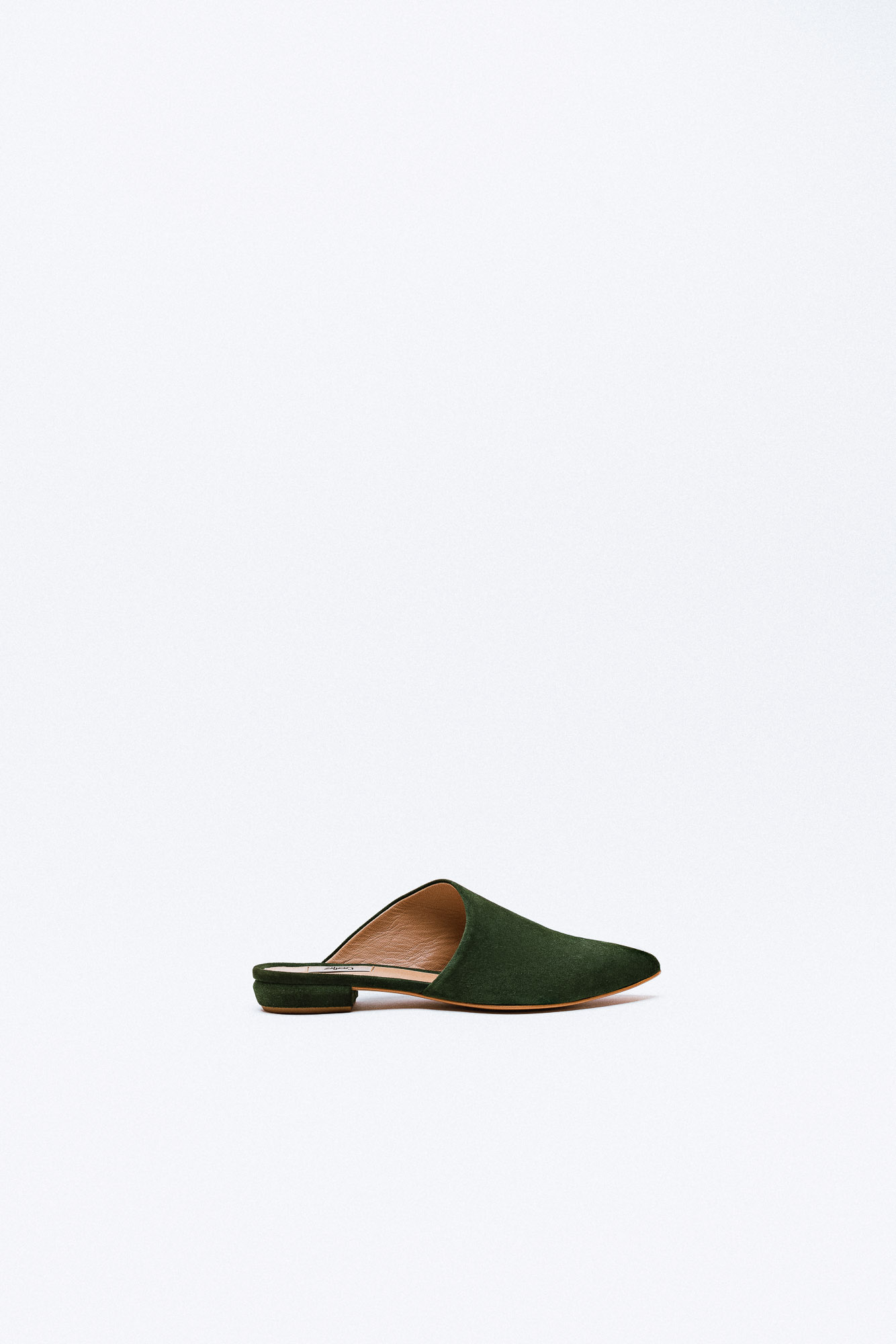 A forest green suede mule with a low heel and pointed toe.